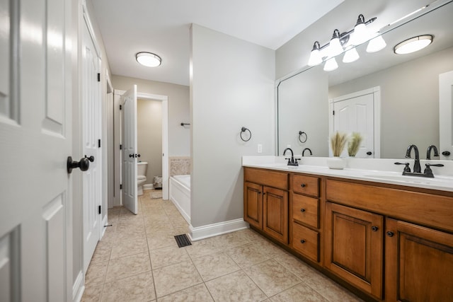 bathroom with vanity, a washtub, tile patterned floors, and toilet