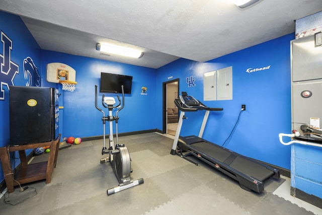 workout area featuring electric panel and a textured ceiling