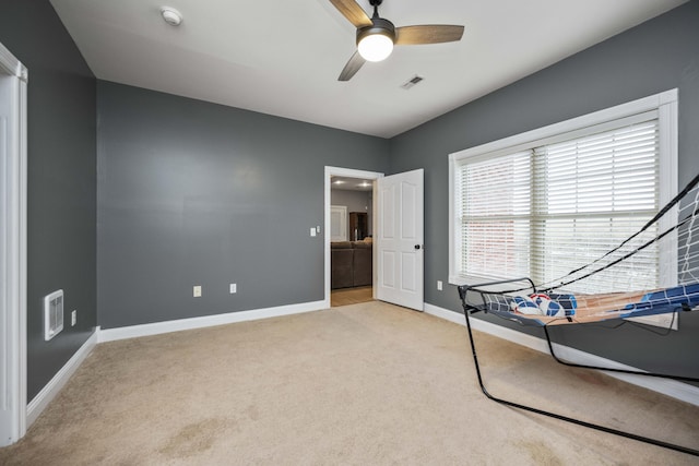 interior space featuring light colored carpet and ceiling fan