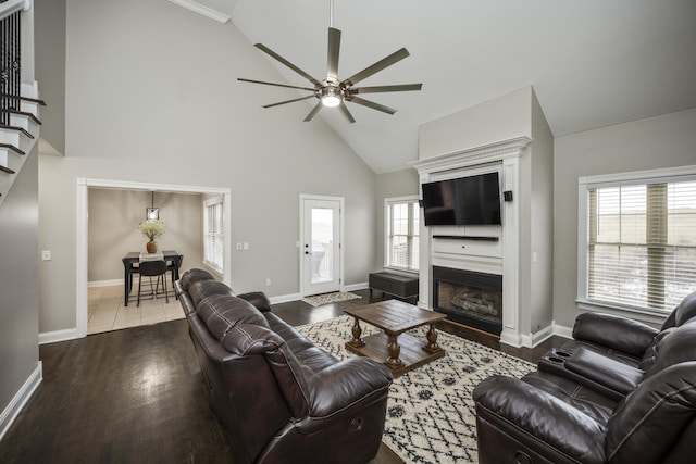 living room with ceiling fan, plenty of natural light, high vaulted ceiling, and wood-type flooring