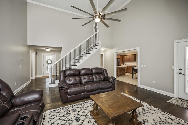 living room featuring a high ceiling, crown molding, ceiling fan, and dark hardwood / wood-style flooring