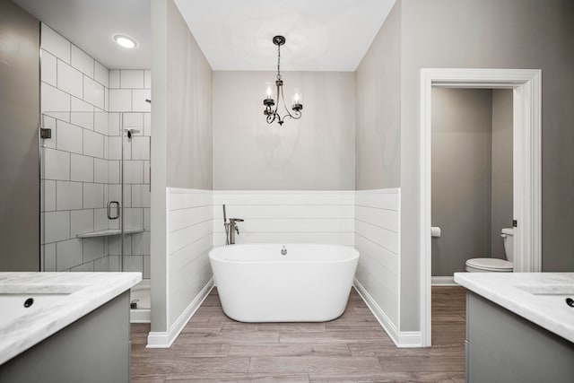 full bathroom featuring hardwood / wood-style floors, vanity, shower with separate bathtub, and toilet