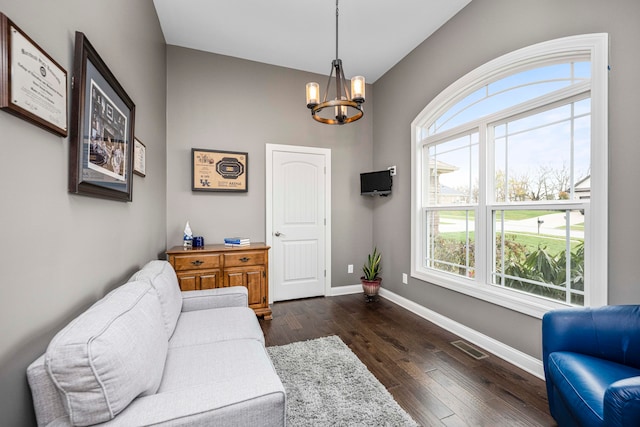 living room with a notable chandelier and dark hardwood / wood-style floors