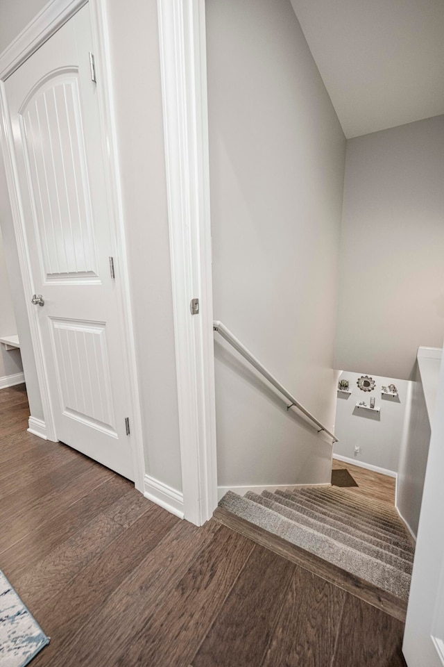 stairs with wood-type flooring and vaulted ceiling