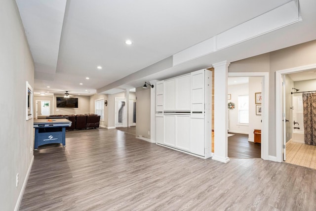 unfurnished living room featuring wood-type flooring and ceiling fan