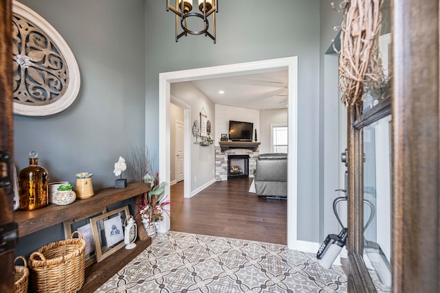 entryway featuring a fireplace, light hardwood / wood-style floors, and an inviting chandelier