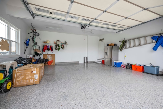 garage featuring stainless steel fridge and a garage door opener