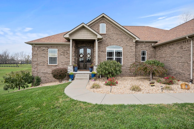 view of front facade with a front yard and french doors