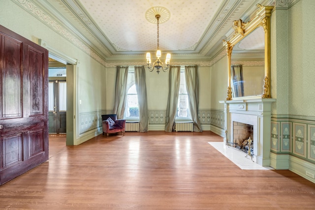 interior space featuring crown molding, radiator heating unit, and light wood-type flooring