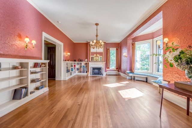 interior space featuring hardwood / wood-style flooring, ornamental molding, radiator, and an inviting chandelier