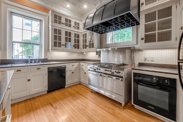 kitchen with sink, white cabinets, black appliances, and light wood-type flooring