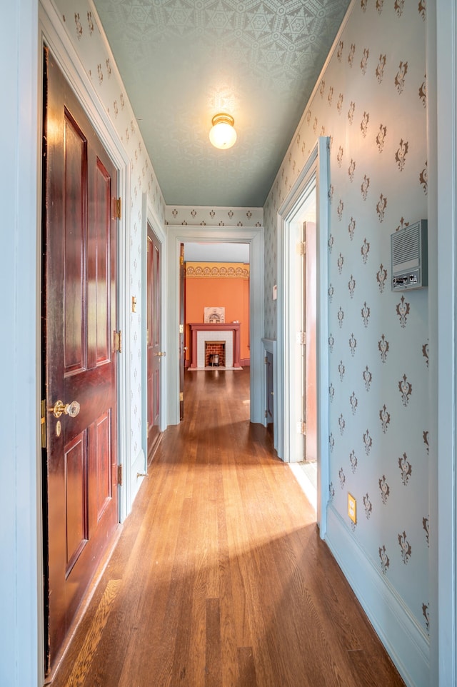 hallway with light wood-type flooring and a textured ceiling