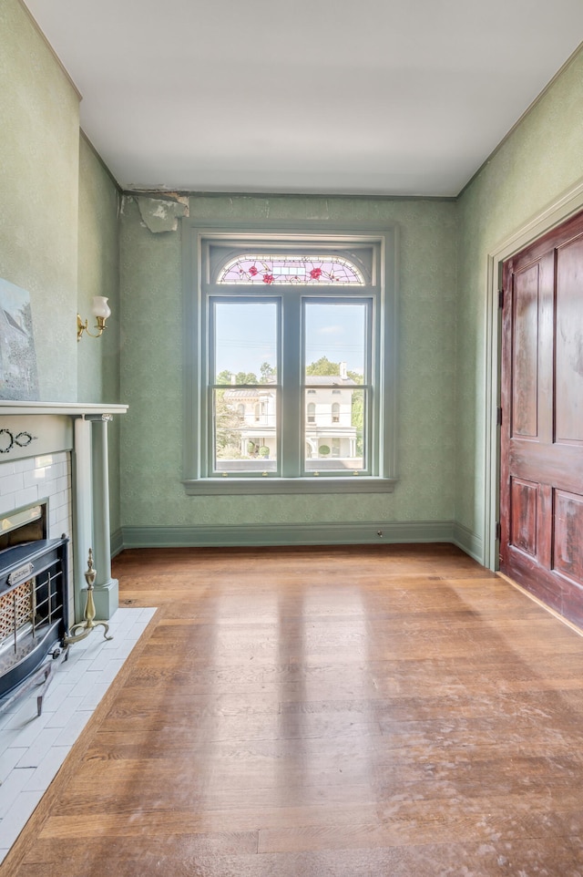 unfurnished living room with light hardwood / wood-style floors and a wood stove