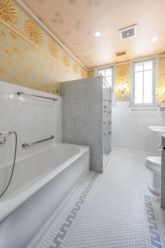 bathroom featuring tile patterned flooring, toilet, and a bathing tub