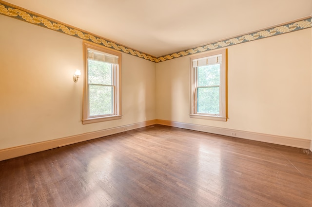 spare room featuring a healthy amount of sunlight and hardwood / wood-style flooring