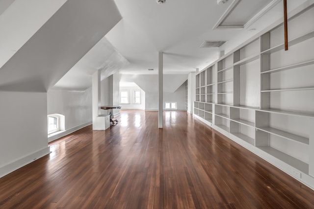 additional living space featuring plenty of natural light and dark hardwood / wood-style floors