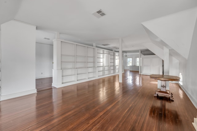 unfurnished living room featuring built in shelves and hardwood / wood-style floors