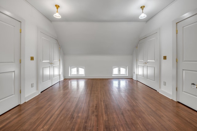 additional living space with dark hardwood / wood-style floors and vaulted ceiling