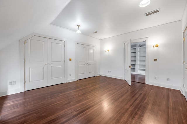 additional living space featuring dark hardwood / wood-style flooring and built in features