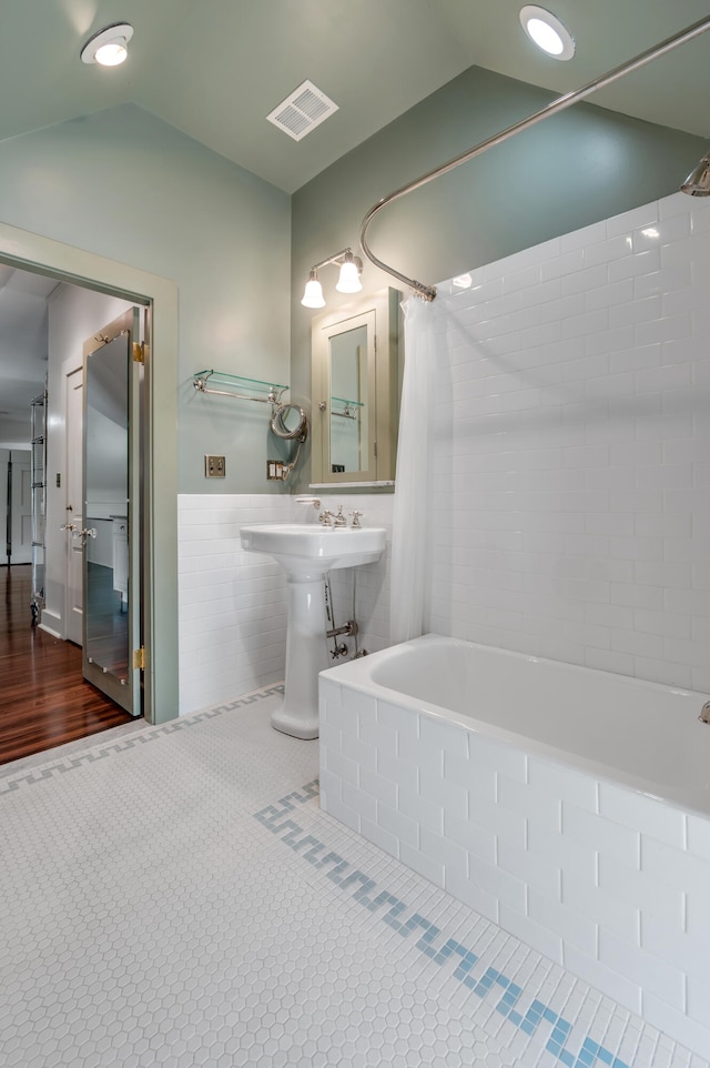 bathroom featuring shower / bathtub combination with curtain and vaulted ceiling