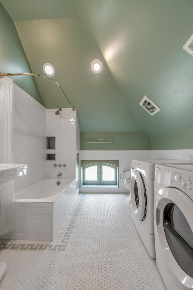 clothes washing area with light tile patterned floors and independent washer and dryer