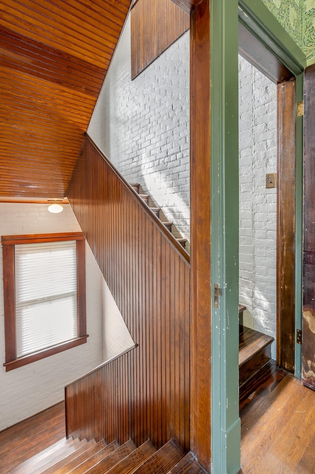 staircase featuring wood ceiling and hardwood / wood-style flooring