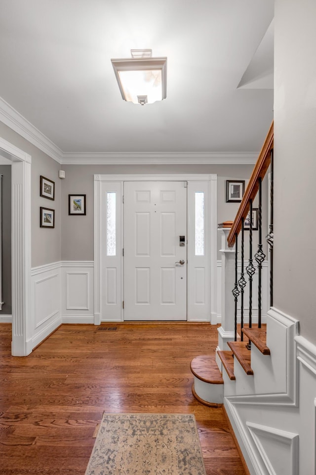 entrance foyer featuring hardwood / wood-style floors and crown molding