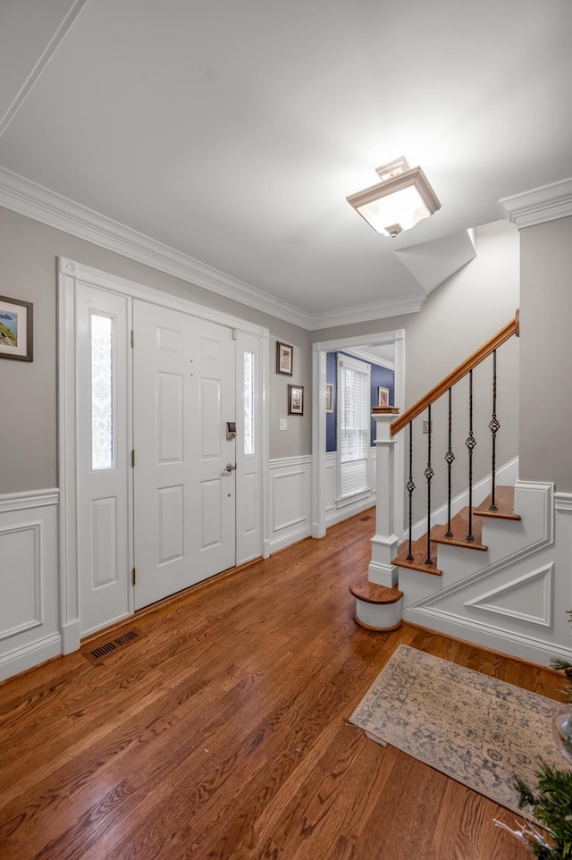 entrance foyer with crown molding and hardwood / wood-style floors