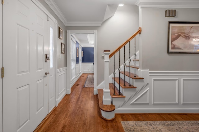 foyer entrance with hardwood / wood-style floors and ornamental molding