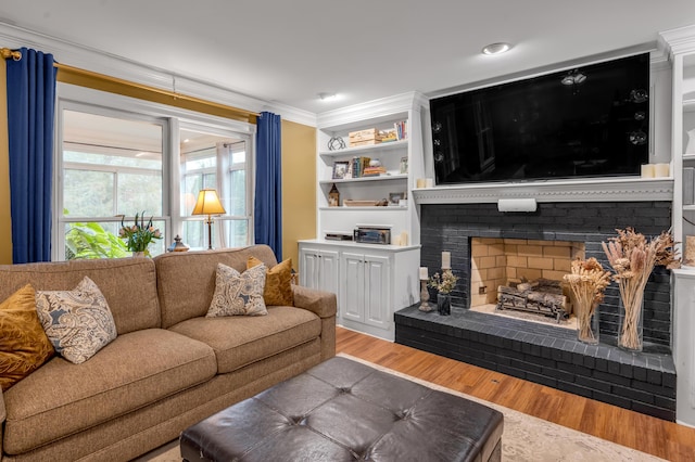 living room featuring wood-type flooring, a brick fireplace, and crown molding