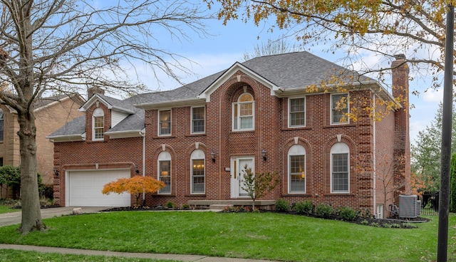 colonial inspired home with cooling unit, a garage, and a front yard