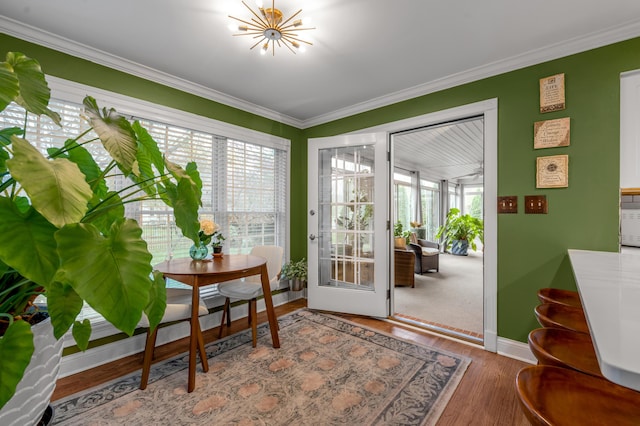 entryway with ornamental molding, hardwood / wood-style floors, and an inviting chandelier