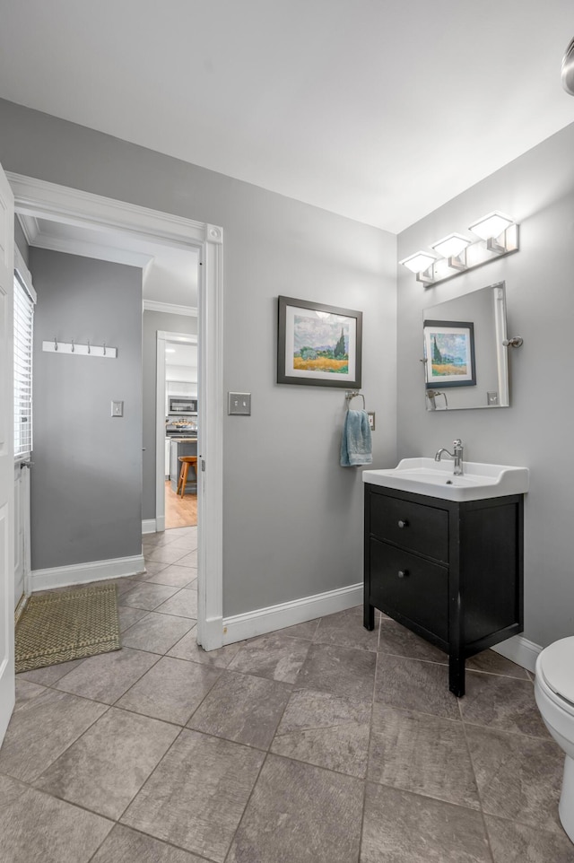 bathroom featuring vanity, ornamental molding, and toilet