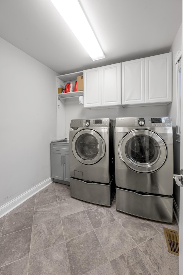 laundry area featuring cabinets and washing machine and clothes dryer