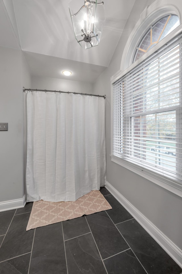 bathroom featuring tile patterned flooring, lofted ceiling, and a healthy amount of sunlight