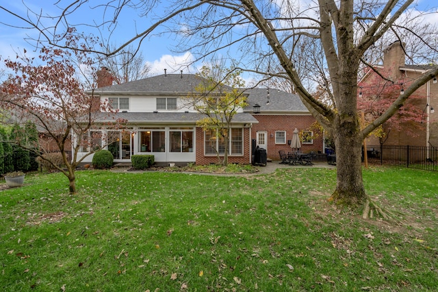 rear view of property with a yard and a patio