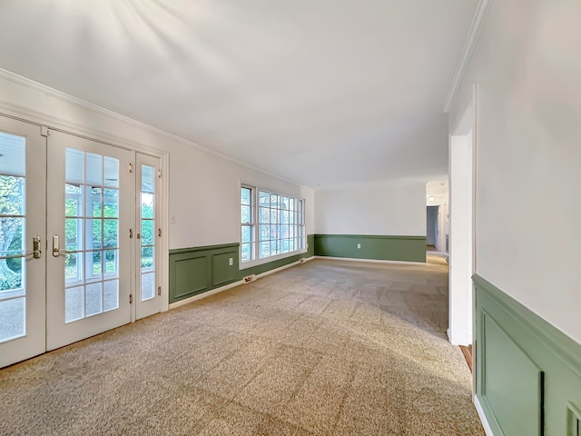 carpeted spare room featuring crown molding and french doors