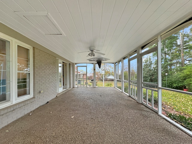 unfurnished sunroom with ceiling fan and wooden ceiling