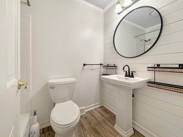 bathroom with hardwood / wood-style floors, ornamental molding, and toilet