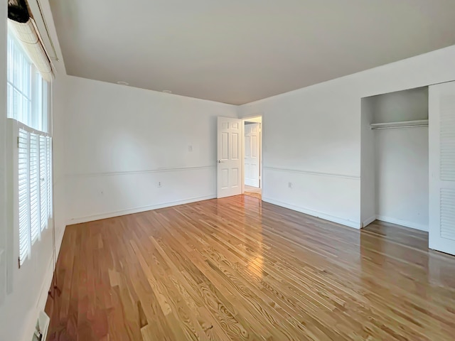 unfurnished bedroom with a closet and light wood-type flooring