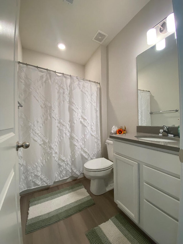 bathroom featuring vanity, hardwood / wood-style flooring, and toilet