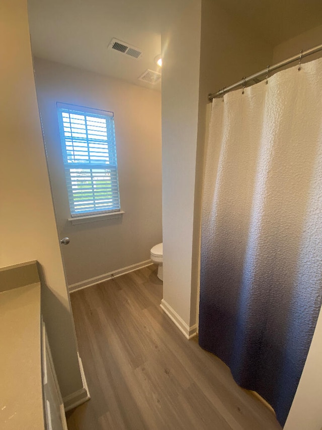 bathroom with wood-type flooring and toilet