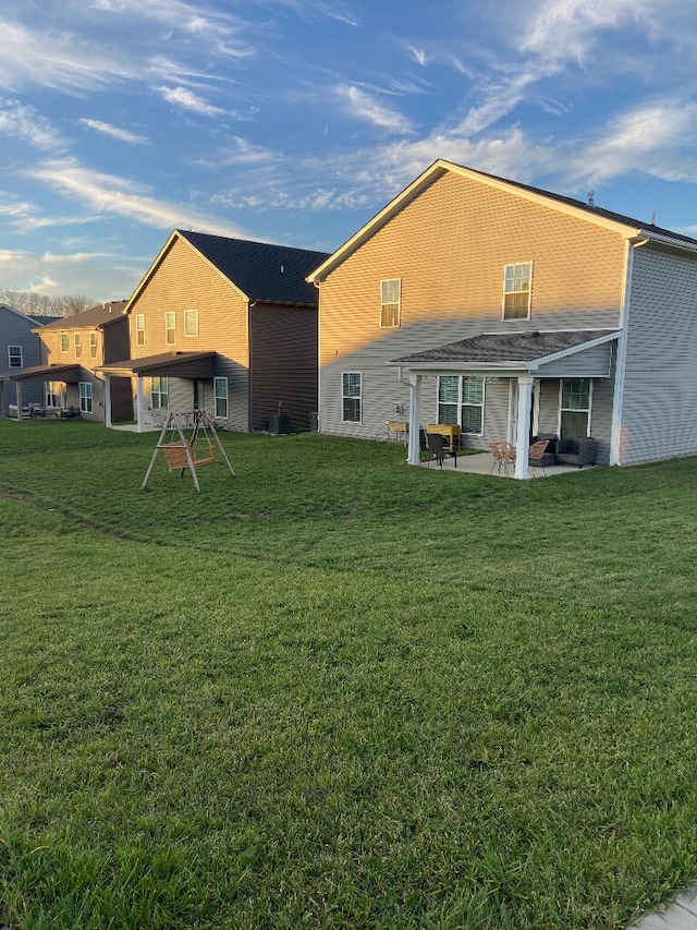 rear view of property with a lawn and a patio