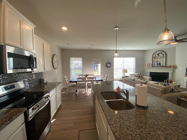 kitchen with hanging light fixtures, white cabinetry, plenty of natural light, and stainless steel appliances