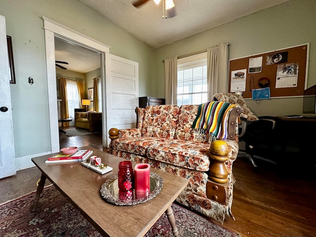 living room with a textured ceiling, ceiling fan, and dark wood-type flooring