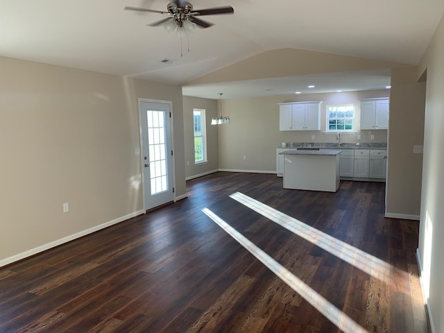 kitchen with lofted ceiling, dark hardwood / wood-style flooring, white cabinetry, and ceiling fan with notable chandelier