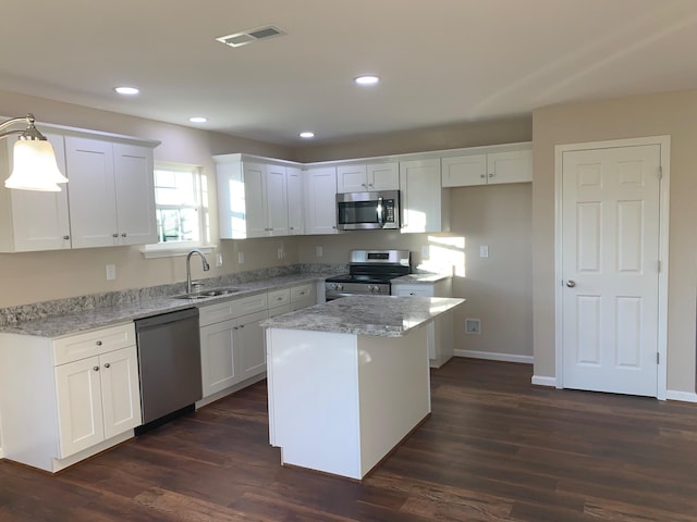 kitchen with a center island, white cabinetry, dark wood-type flooring, and appliances with stainless steel finishes