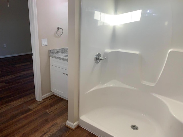 bathroom featuring hardwood / wood-style floors, vanity, and walk in shower