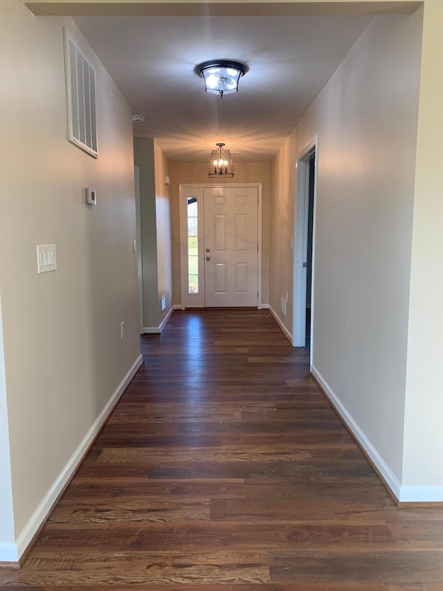 interior space with a chandelier and dark wood-type flooring