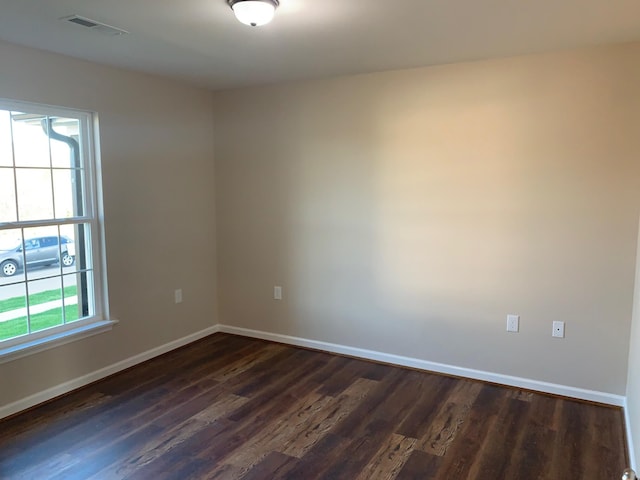 empty room with dark hardwood / wood-style flooring